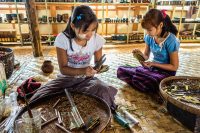 Young girls hard at work fabricating cheroot cigarettes.