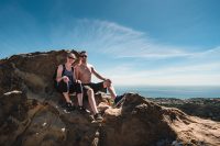 Siblings chilling atop Skull Rock on the Temescal Canyon Trail in Topanga State Park in Los Angeles, California.