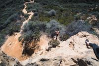 Scrambling up the rocks at the top of Temescal Canyon Trail in Topanga State Park in Los Angeles, California.