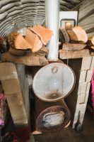 The Camp Haven host family resides in a camper set-up in a kit building heated by this wood stove.